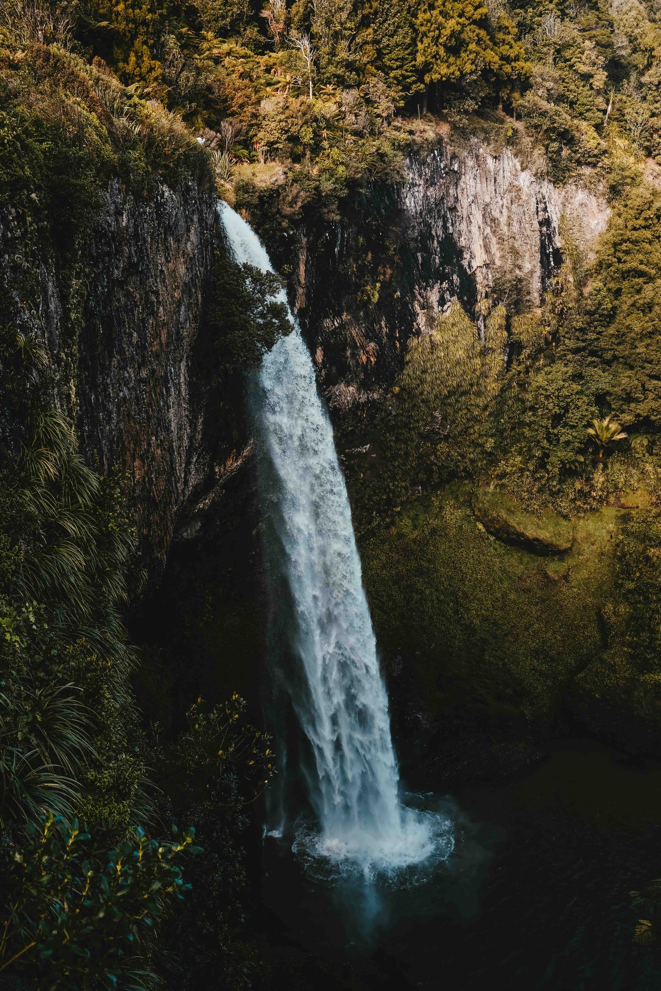 tiro-vertical-de-la-cascada-y-el-lago-por-los-acantilados-cubiertos-de-hierba